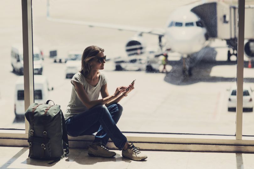 girl in the airport looking in smartphone